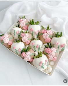 a box filled with white and pink chocolate covered strawberries on top of a table