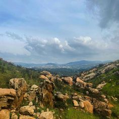 the rocky terrain is covered in green grass and rocks, with mountains in the distance