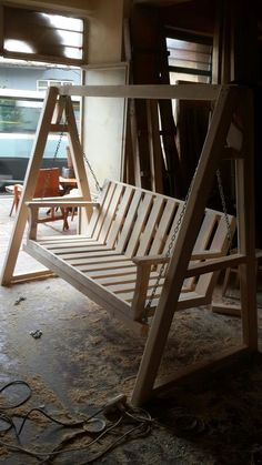 a wooden swing sitting in the middle of a room