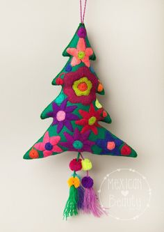 a colorful christmas tree ornament hanging on a wall