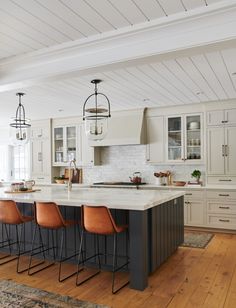 a large kitchen with an island and bar stools