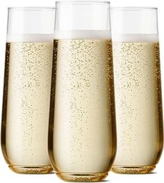 three champagne glasses filled with liquid on a white background