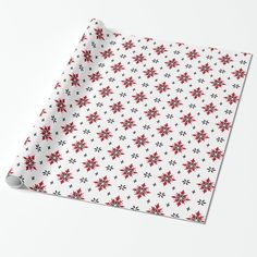 a white wrapping paper with red and black snowflakes on it's surface