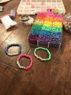 several bracelets and beads are sitting on the table next to some plastic storage containers