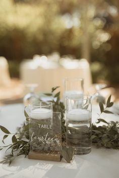 the table is set with candles and greenery