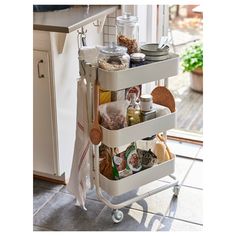 a kitchen cart filled with lots of food on top of a tiled floor next to a window