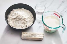 ingredients to make cake sitting on a counter next to a measuring cup and glass container