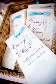 the wedding stationery is laid out in a wicker basket for guests to use