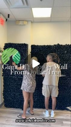 two people standing in front of giant flower wall