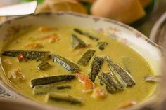 a bowl filled with soup and vegetables on top of a table