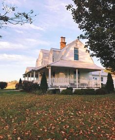 a large white house sitting on top of a lush green field