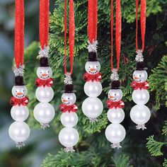 christmas ornaments hanging from a tree with snowmen and red bows on them, all decorated in white pearls