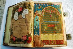 an old book opened on top of a white tablecloth covered surface with writing and flowers