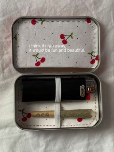 an open tin with some writing in it on a white tablecloth and red cherries