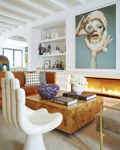 a living room filled with furniture and a fire place next to a painting on the wall