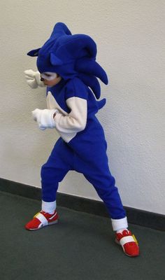 a person in a blue sonic costume standing next to a wall