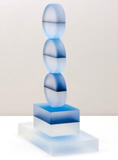 a blue and white sculpture sitting on top of a white table next to a wall