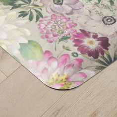 an area rug with flowers on it sitting on the floor next to a pair of scissors