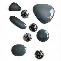 several black and white stones are arranged on a white surface, including one in the middle