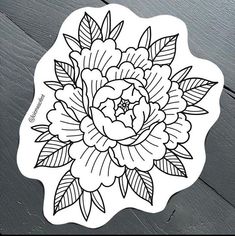 a black and white flower sticker sitting on top of a wooden table