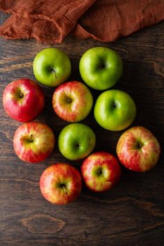 several apples are arranged on a wooden table