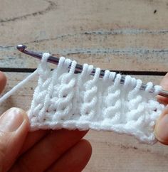 someone crocheting the end of a piece of white yarn