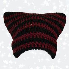 a red and black crocheted hat on top of a white star pattern background