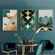 three paintings hang on the wall above a table with two chairs in front of it