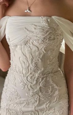 the back of a woman's wedding dress with an embellishment on it