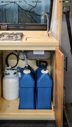 two blue and white tanks under a mirror on a shelf next to a stove top oven