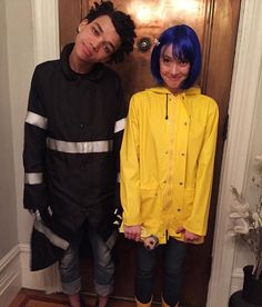 two people standing next to each other in front of a door wearing yellow raincoats