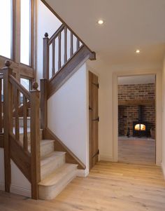 a wooden staircase leading up to a brick oven in a home with white walls and wood floors