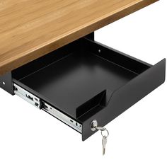 an open drawer underneath a wooden table with a key in the bottom compartment and two keys hanging from it