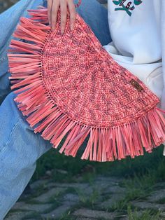 a woman is holding a pink purse on her lap