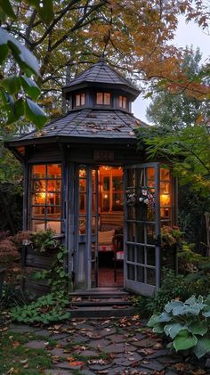 a small gazebo in the middle of a garden with lots of leaves on the ground