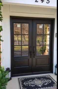 the front door is black and has two glass doors with numbers on each one side