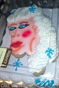 a cake in the shape of a woman's head with blue eyes and hair