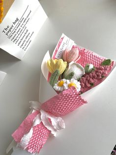 some paper flowers are sitting on top of a white table and next to a piece of paper