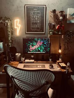 a desk with a computer monitor, keyboard and mouse on it in front of a painting