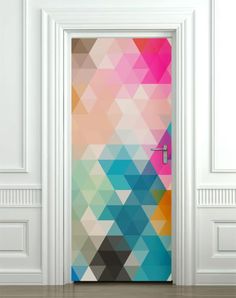 an open door with a colorful geometric design on the front and side panels, in a white room