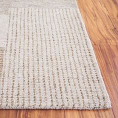 a close up of a rug on the floor with wood floors and hard wood planks