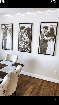 a dining room table with chairs and pictures hanging on the wall above it in black and white