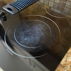 a black stove top with two burners on it and an oven door is open