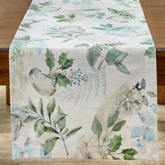 an image of a table cloth with flowers and leaves on it in front of a wooden table