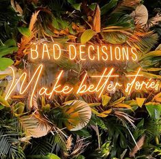 a neon sign that says bad decision make better stories on the side of a tree