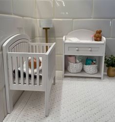 two white cribs and a baby's bed in a room with tiled walls