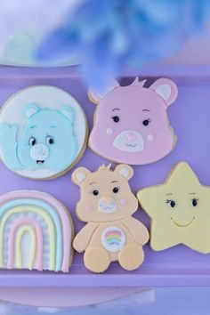 there are some cookies in the shape of bears and rainbows on this purple tray