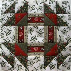 a quilted square with red and green designs on it