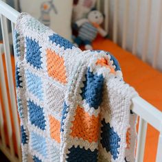 a crocheted blanket is draped over a crib