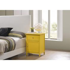 a bed with a yellow nightstand next to it